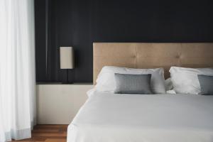圣马力诺The Regent Boutique Hotel & Spa PRE OPENING的卧室配有一张带白色床单和枕头的大床。