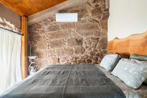 曼瓜尔迪Segredos da Montanha - Mangualde的石墙房间内的一张床位