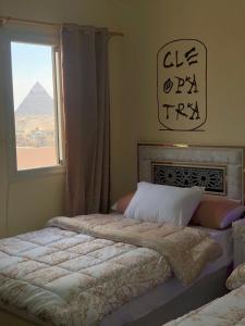 开罗Sneferu Pyramids inn - Full Pyramids View的一间卧室配有一张床,享有金字塔的景色