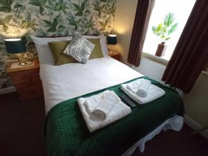斯凯格内斯Brackenhurst Guest House的一间卧室配有带毛巾的床
