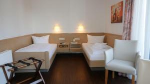 SchallbachHotel Garni Alte Post的酒店客房,配有两张床和椅子