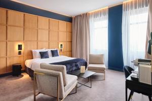 波尔多Maison Heym Bordeaux的配有一张床和一把椅子的酒店客房
