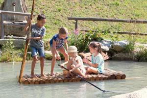 瓦尔奥纳的圣乔凡尼Enzianhof - Nature Apartments的一群孩子在水中的木筏上