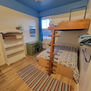七岛市乐塔甘奥贝格国际酒店的一间卧室配有一张双层床、一张桌子和一张双层床。