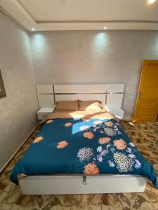 达赫拉دار الياقوت Dar Al Yaqut的一间卧室配有一张带蓝色棉被的床