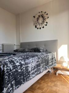 克劳德Jeux Olympique au Cœur de Paris的卧室配有一张床,墙上挂着一个钟