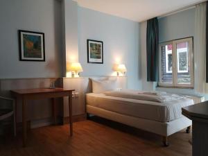 柏林阿尔特市场酒店的一间卧室配有一张床、一张桌子和一个窗户。