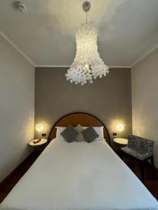 米兰米兰德勒纳泽欧尼酒店的一间卧室配有一张大床和一个吊灯。