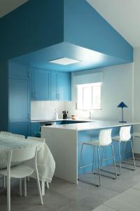 珀彻斯A Casa da Porta Azul的厨房配有蓝色橱柜和桌椅