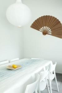珀彻斯A Casa da Porta Azul的一间白色的房间,配有一张桌子和两把遮阳伞