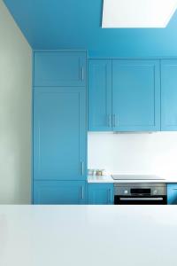 珀彻斯A Casa da Porta Azul的厨房配有蓝色橱柜和炉灶。