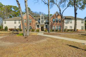 默特尔比奇Murrells Inlet Condo with Pool Access, Near Beach!的前面有树木的大房子