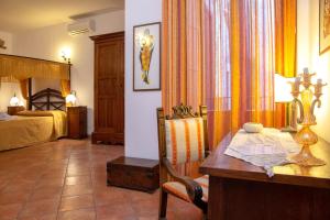 特罗佩阿多娜西西纳旅馆的一间带书桌和床的房间以及一间卧室