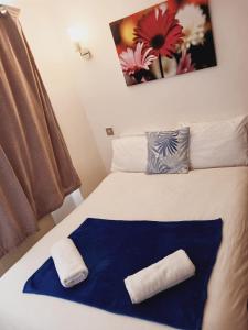 伦敦F304-Lovely 3rd Flr Studio fits 2 Near Hyde Park的床上有蓝色和白色的毯子