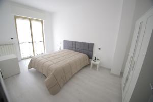 San Ferdinando di PugliaIl nascondiglio的白色的卧室设有床和窗户