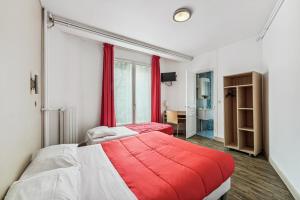 巴黎托尔比亚克酒店的一间卧室配有两张床和红色毯子