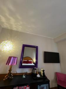 米兰米兰德勒纳泽欧尼酒店的一间设有镜子和一张带台灯的桌子的房间