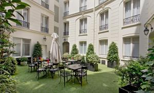 巴黎埃利塞公寓式酒店的建筑前方的庭院配有桌椅