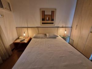贝洛奥里藏特Flat Pancetti的卧室配有白色大床和床头柜。