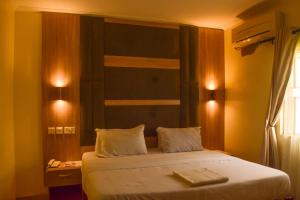 Ijesa-TedoLisgewann Global Hotel的一间卧室配有一张带白色床单的床和窗户。