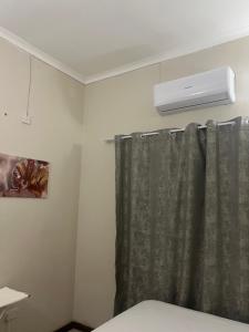 哈博罗内Brilliant Home的带淋浴帘和空调的浴室