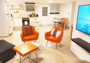 Gan H̱ayyimSpacious and Peaceful 2BD with a Garden & Parking的客厅配有橙色椅子和平面电视