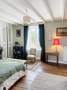 Gatteville-le-PhareLA FERME DE NEHOU的卧室配有床、椅子和窗户。