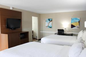 阿比林Baymont by Wyndham Abilene的酒店客房设有两张床和一台平面电视。
