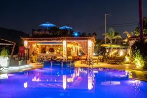 蒂加基苏格拉底公寓的游泳池在晚上餐厅前