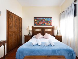 Las CrucesLive Garachico Villa Daute con terraza y piscina的一间卧室配有蓝色的床和两个枕头