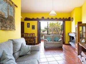 Las CrucesLive Garachico Villa Daute con terraza y piscina的客厅设有黄色的墙壁和沙发