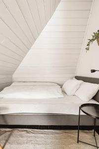 卑尔根2024 Renovated Luxury Penthouse! Up To 9 Guests!的一张带白色床单的床和一把椅子