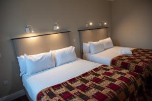 多尼戈尔Donegal House的酒店客房,配有两张带白色床单的床