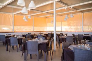 佩斯基奇Villaggio Turistico Grotta dell'Acqua的用餐室设有桌椅和窗户。