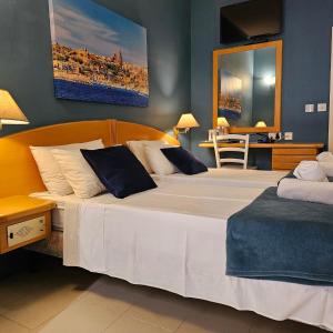马萨尔福恩La Playa Hotel的卧室配有白色大床和蓝色的墙壁