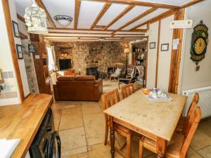 纳伯斯1 Mill Farm Cottages的厨房以及带桌椅的起居室。