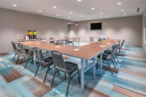 塔尔萨Home2 Suites By Hilton Tulsa Airport的大型会议室,配有长桌子和椅子