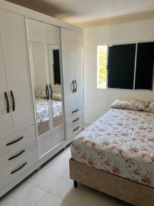 塞拉Ap202 Vista Praia de Bicanga的卧室配有白色橱柜、床和窗户。