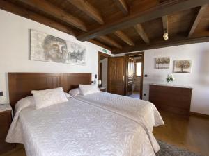 阿里翁达斯Casa El Molín 3 Soto de Dueñas的一间卧室设有一张大床和木制天花板。