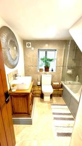 彭里斯Swallow Barn的浴室配有盥洗盆、卫生间和浴缸。