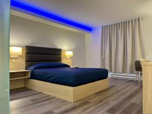 MascoucheMotel Mascouche的一间卧室配有一张蓝色床罩的床