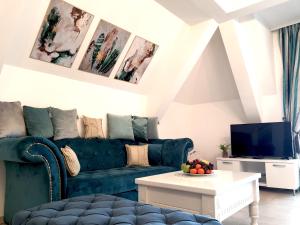 兹拉蒂博尔Zlatibor Hills Apartments Wellness & Spa的客厅配有绿色沙发和电视