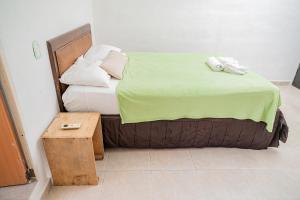 坎昆Casa Playa Hermosa的一张带绿毯和木桌的床