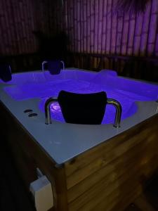 瓜塔佩Ibuku Hotel Guatapé - Chalets的客房内的按摩浴缸配有紫色照明
