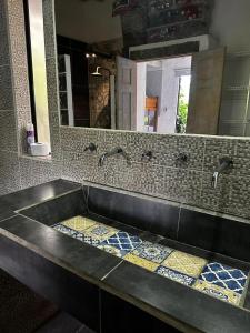 瓜塔佩Ibuku Hotel Guatapé - Chalets的浴室水槽设有2个水龙头和镜子