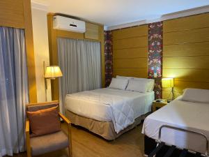 圣保罗Flat próximo Congonhas的酒店客房,配有两张床和椅子