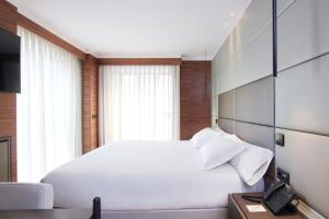 莱昂Hotel MyPalace León的卧室配有白色的床和电话