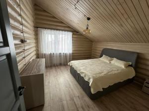 KuprinkaБозайгыр的一间卧室设有一张床和木制天花板