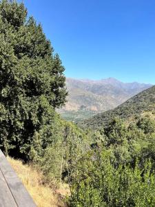 圣地亚哥Cabaña ecológica y aislada的享有树木和山脉的山丘美景