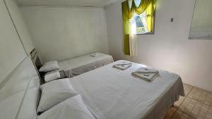 本图贡萨尔维斯Casa de Campo em Bento Gonçalves的客房设有两张床和窗户。
